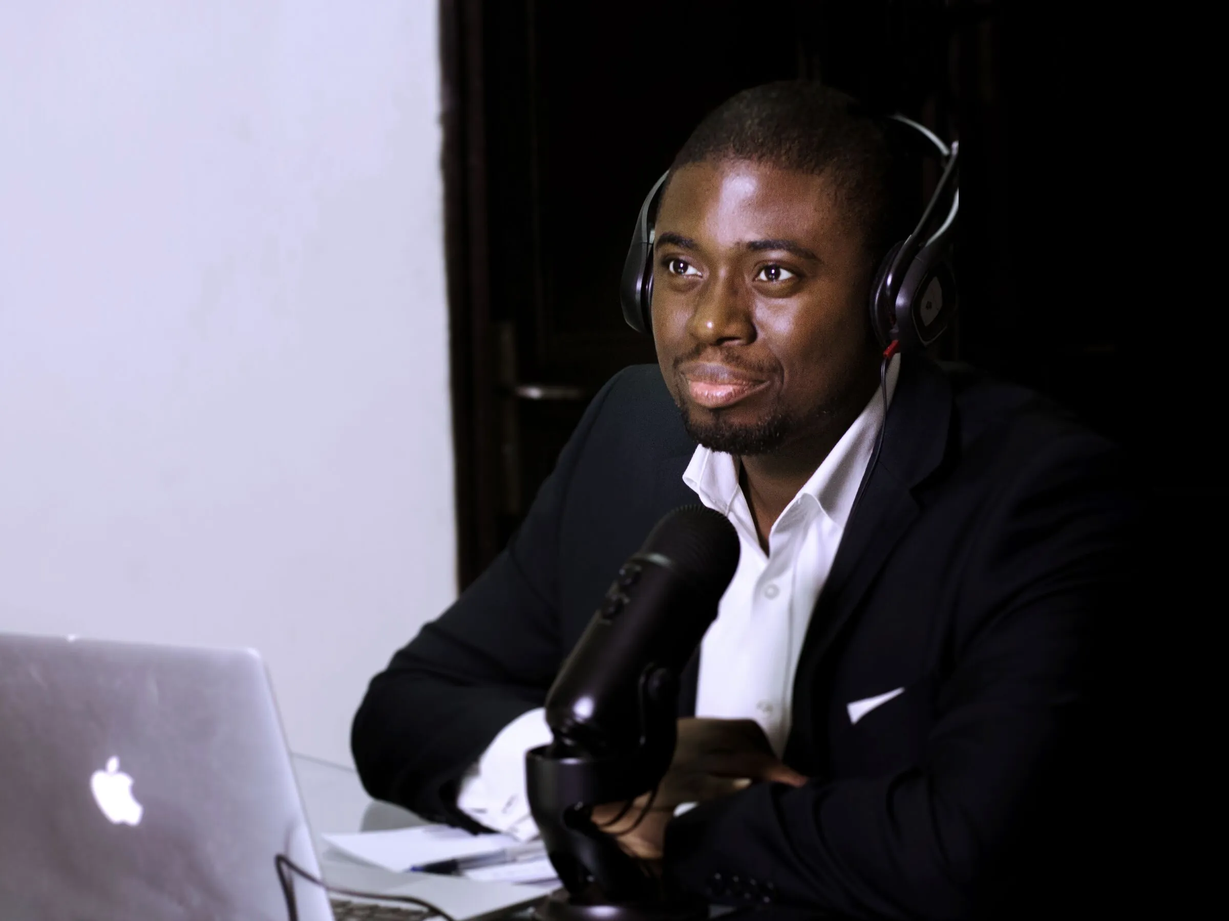 Chi Odogwu in headphones behind a podcast microphone